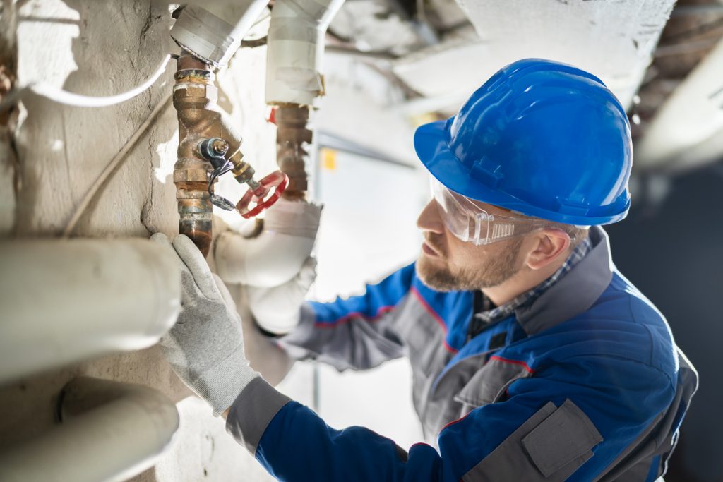 Male Worker Inspecting Valve